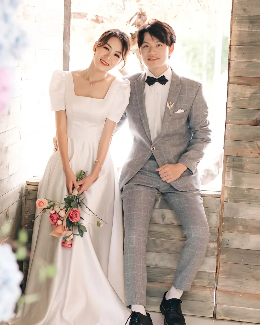 花に囲まれて並んで座る新郎新婦（イメージ）
